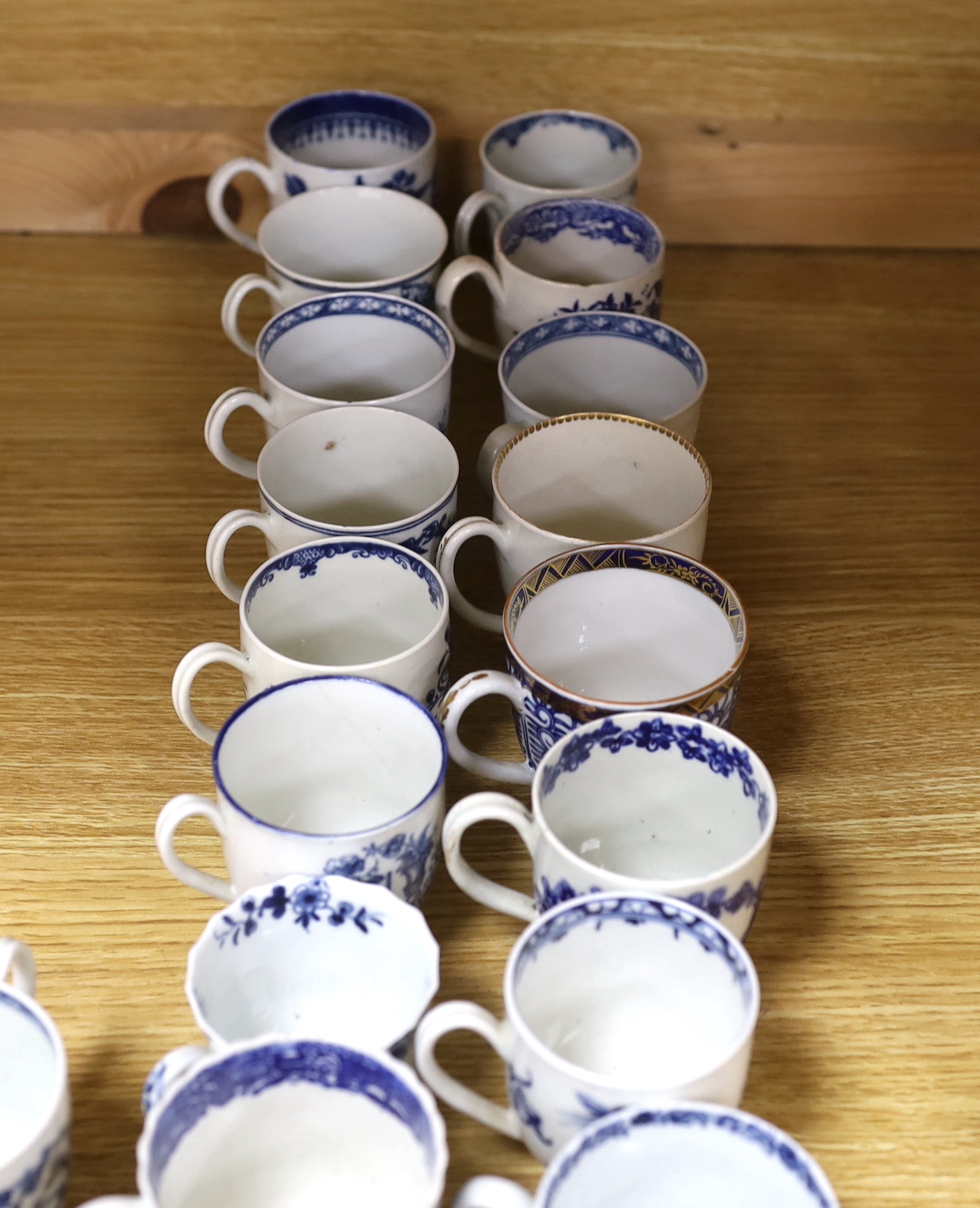A collection of late 18th century Worcester, Caughley etc. blue and white coffee cups and saucers, the largest 12cm in diameter